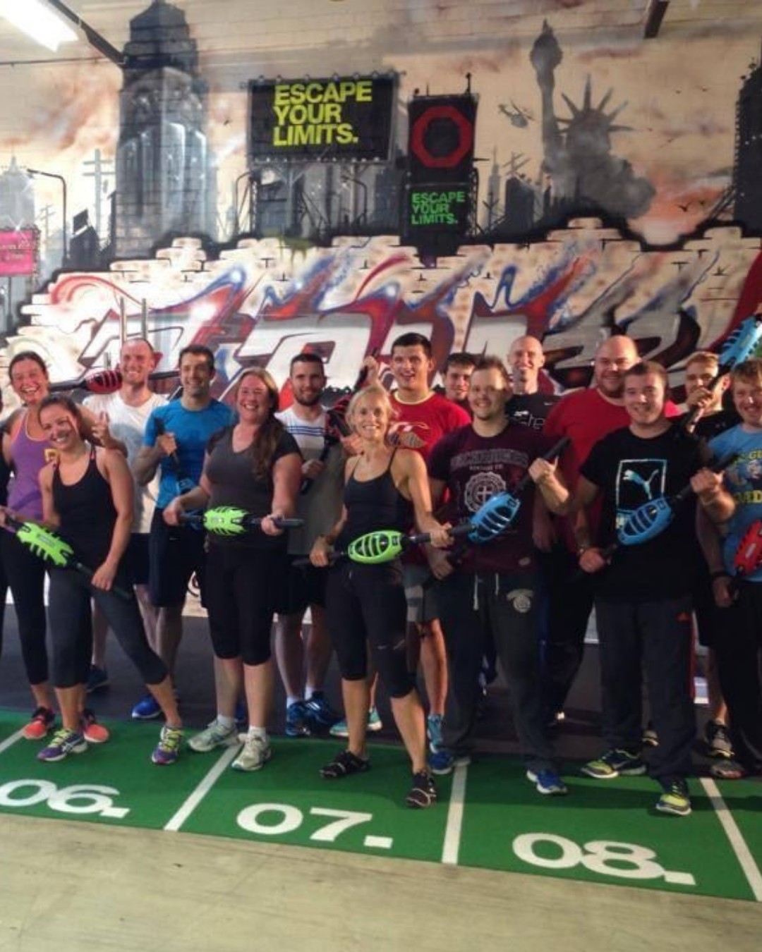 A big class group photo in front of a graffiti wall